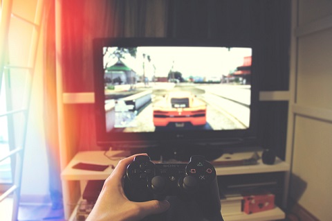 A hand holding controller and playing a game