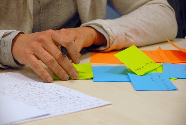 Brainstorming game ideas on sticky notes and writing each idea in details on papers